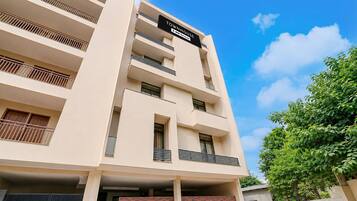 A multi-story building with a sign indicating it is a serviced apartment complex.
