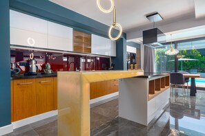 A modern kitchen with a central island, built-in appliances, and a view of the outdoors.