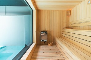 A sauna with wooden benches and a small wooden bucket.
