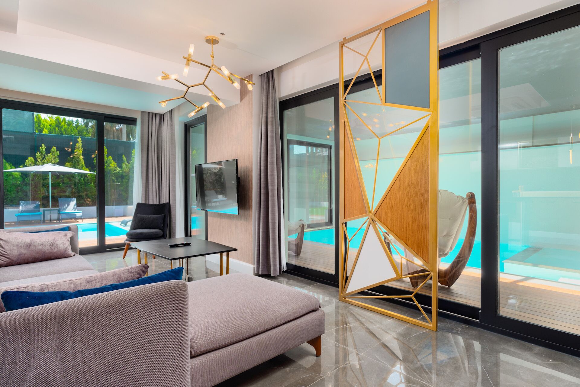 Uma sala de estar moderna com um sofá, uma televisão e vista para a piscina.