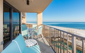 Ein Balkon mit Blick auf den Strand, Sitzgelegenheiten im Freien und einer Geländer.