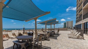 Een terras op het dak met buitenmeubilair en uitzicht op de oceaan.