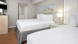 Habitación de hotel con una cama grande, mesitas de noche, un televisor y un cuadro en la pared.