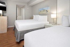 A hotel room with a large bed, bedside tables, a television, and a painting on the wall. - Island Winds East 808 2 Bedroom Condo (Gulf Shores)