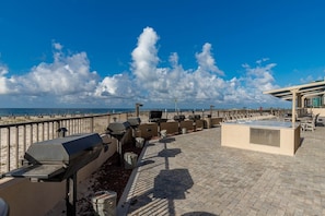 A rooftop terrace with barbecue grills, seating areas, and a view of the beach. - Phoenix X 306 3 Bedroom Condo (Orange Beach)