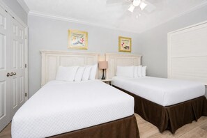 A hotel room with two beds, a ceiling fan, and two framed pictures on the wall. - Phoenix X 306 3 Bedroom Condo (Orange Beach)