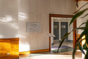 A reception area with a sign for 'PESCA Waikiki Beach' and a 'Fire Exit' sign. - Gorgeous 2bd/2ba Ilikai Suite Steps from the Sand! (Honolulu)