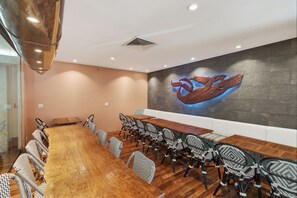 A conference room with a long wooden table, black and white patterned chairs, and a large wall mural of a whale. - 1BR Ocean View Luana Waikiki w/FREE PARKING! (Honolulu)