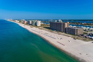 An aerial view of a coastal city with a long sandy beach, high-rise hotels, and a clear blue sky. - Phoenix X 913 3 Bedroom Condo (Orange Beach)