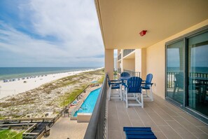 A balcony with a view of a beach and a pool. - Phoenix X 513 3 Bedroom Condo (Orange Beach)