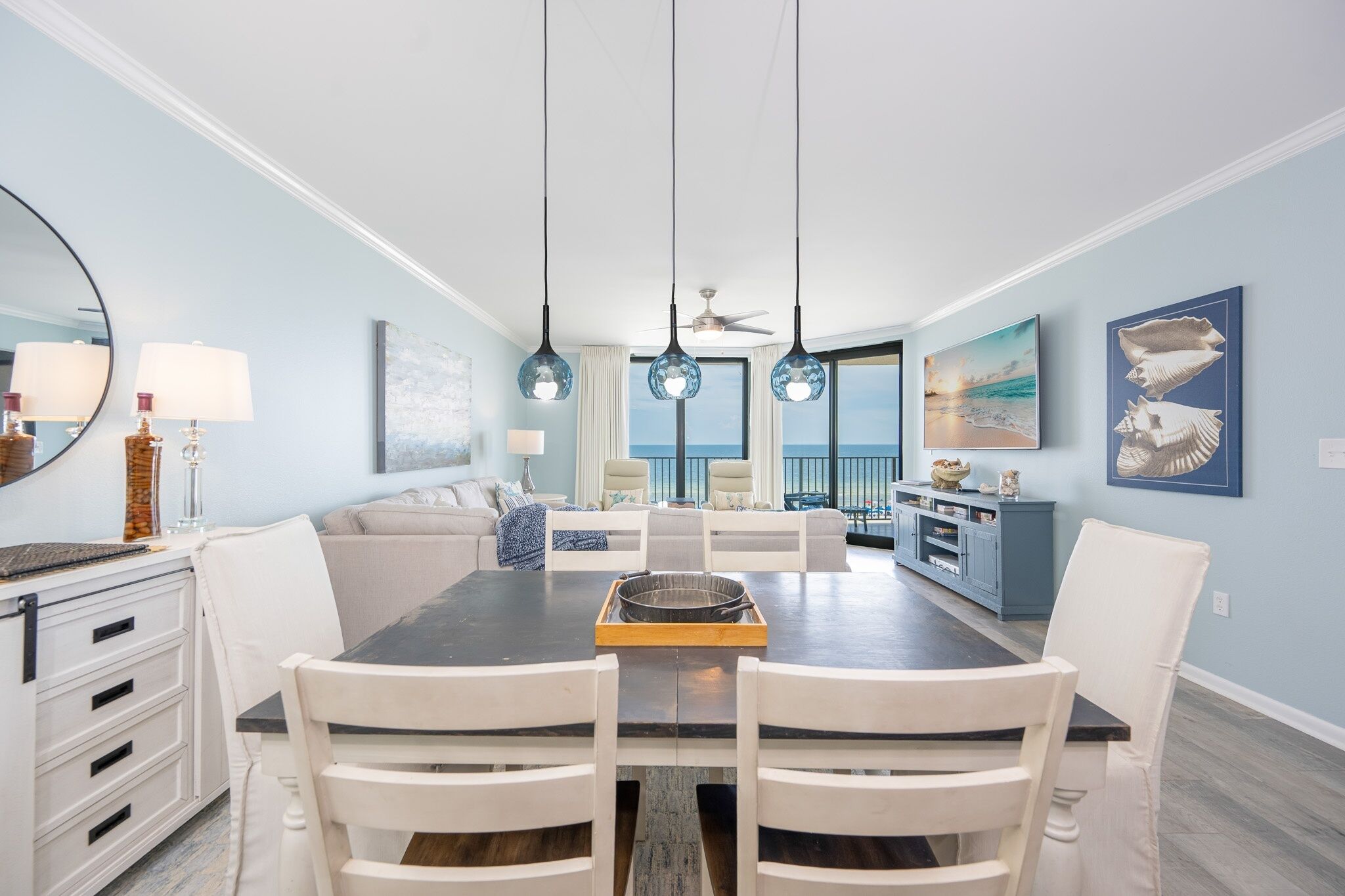 A dining area with a dark table, white chairs, and a central island.