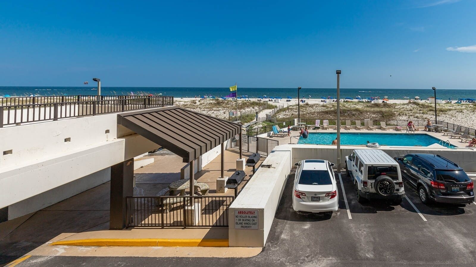 Zona de estacionamiento con piscina, playa y vista al océano.