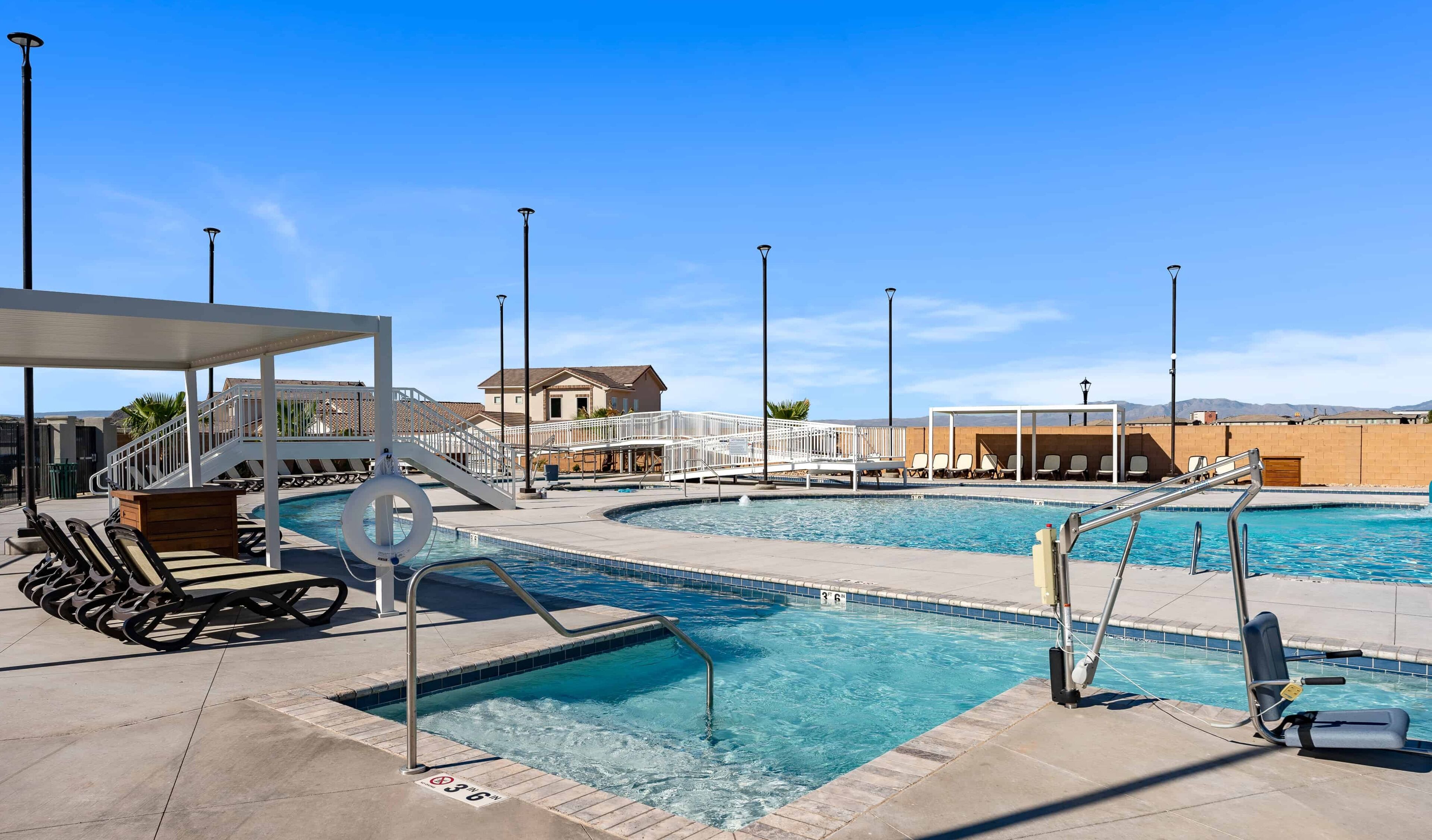 A swimming pool with a lifeguard stand, lounge chairs, and a covered seating area.