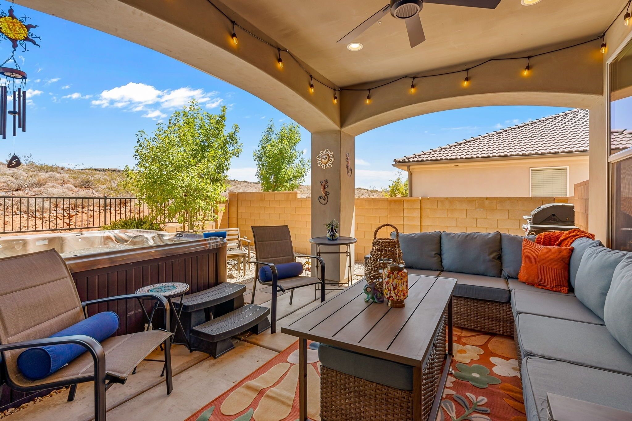 Une terrasse extérieure équipée d’un barbecue, d’un espace salon et d’éléments décoratifs.