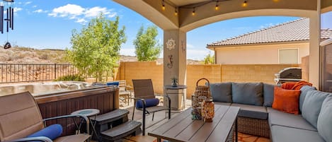 Une terrasse extérieure équipée d’un barbecue, d’un espace salon et d’éléments décoratifs.