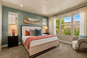 A bedroom with a bed, nightstands, a chair, and large windows with a view. - Papa Oak's Casa 5 Bedroom Home (Washington)