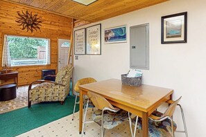 A wooden interior with a dining table, chairs, and a wall-mounted cabinet. - Quiet A-frame Tucked Off the Road in Girdwood (Girdwood)