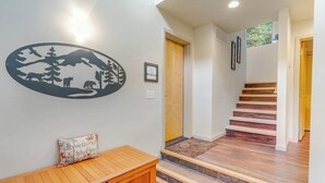 Un pasillo con un banco de madera, un adhesivo en la pared y una escalera.