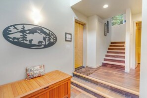 Ein Flur mit einer hölzernen Bank, einer Wanddekoration und einer Treppe.