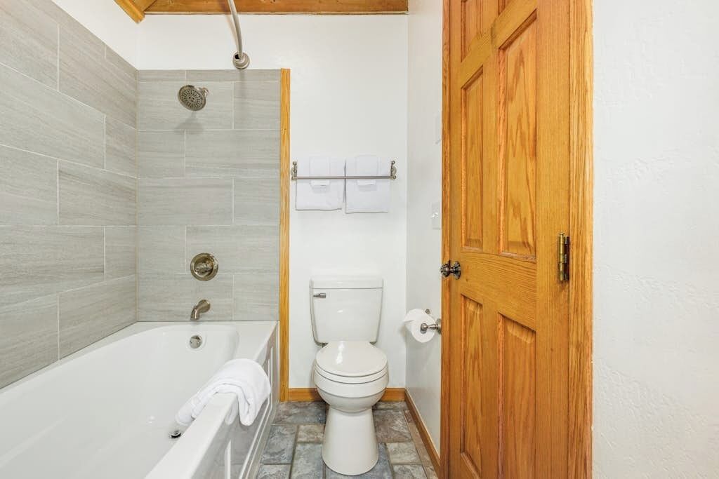 Un baño con bañera, inodoro y ducha.