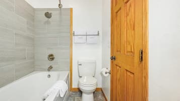 Un baño con bañera, inodoro y ducha.