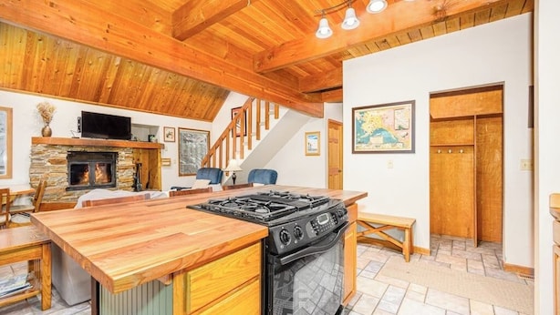 Una cocina con una isla central, estufa y chimenea.