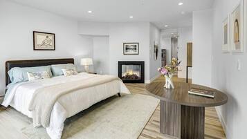 A bedroom with a bed, bedside table, and a fireplace.