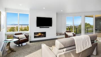 A modern living room with a fireplace, a flat-screen TV, and a sofa.
