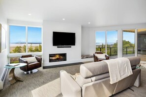 A modern living room with a fireplace, a flat-screen TV, and a sofa.