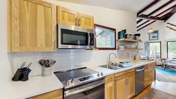 A modern kitchen with wooden cabinets, stainless steel appliances, and a built-in oven.