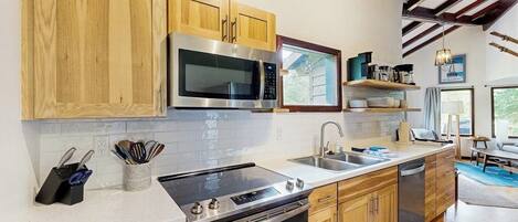 A modern kitchen with wooden cabinets, stainless steel appliances, and a built-in oven.