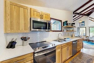 Una cocina moderna con armarios de madera, electrodomésticos de acero inoxidable y horno empotrado.