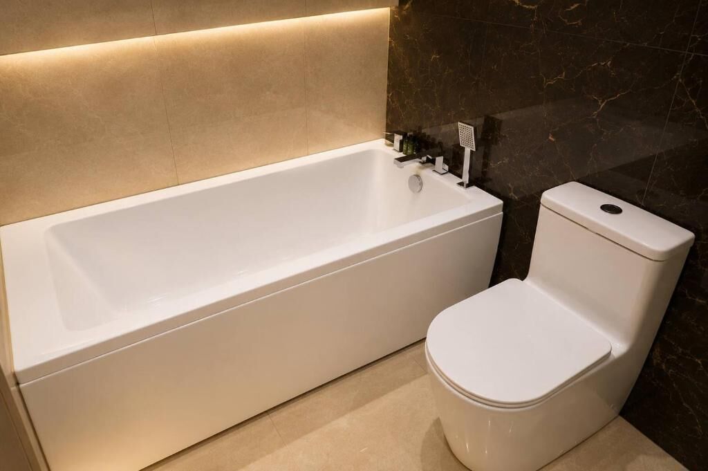 A modern bathroom with a bathtub and toilet.