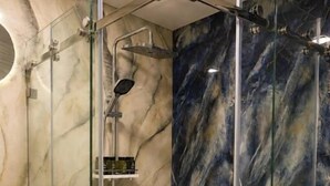 A glass-enclosed shower with a marble wall design. - Amanat Prestige Hotel (Samarkand)