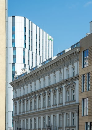 A multi-story building with a classical architectural style, featuring ornate detailing and multiple windows. - RentPlanet - Apartament Żelazna (Warszawa)
