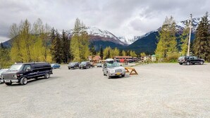 A parking lot with vehicles, a gravel surface, and a mountainous backdrop. - Slopeside Studio at Alyeska w/ Full Kitchen (Girdwood)