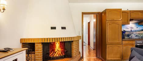Ein Wohnzimmer mit Kamin, Holzschränken und einem Fernseher.