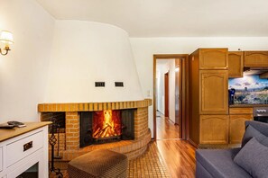 Ein Wohnzimmer mit Kamin, Holzschränken und einem Fernseher.
