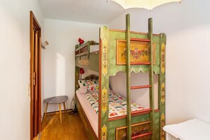 Ein Zimmer mit einem Etagenbett, einem kleinen Tisch und einer Tür.