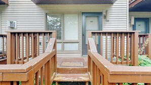 Eine Holztreppe führt zu einer Tür mit einem Fenster darüber.