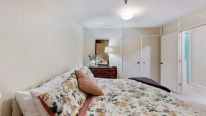 Ein Schlafzimmer mit einem Bett, einem Schminktisch, einem Spiegel und einem Kleiderschrank.