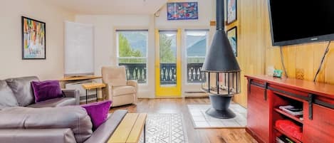 Ein Wohnzimmer mit Sofa, Couchtisch, Fernseher und Kamin.