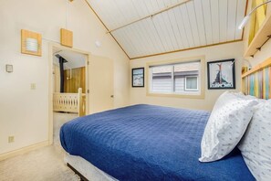 Un dormitorio con cama, ventana y puerta que da a un balcón.