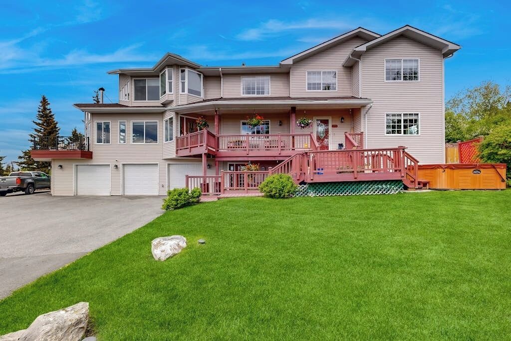 A two-story house with a front porch, a garage, and a well-maintained lawn.