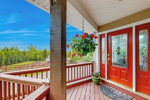 A wooden deck with a red door and a hanging flower basket. - South Anchorage Apartment w/ Shared Deck & Wildlife (Anchorage)