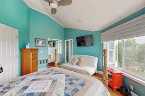 A bedroom with a bed, a dresser, a chair, a television, and a window with a view. - South Anchorage Apartment w/ Shared Deck & Wildlife (Anchorage)