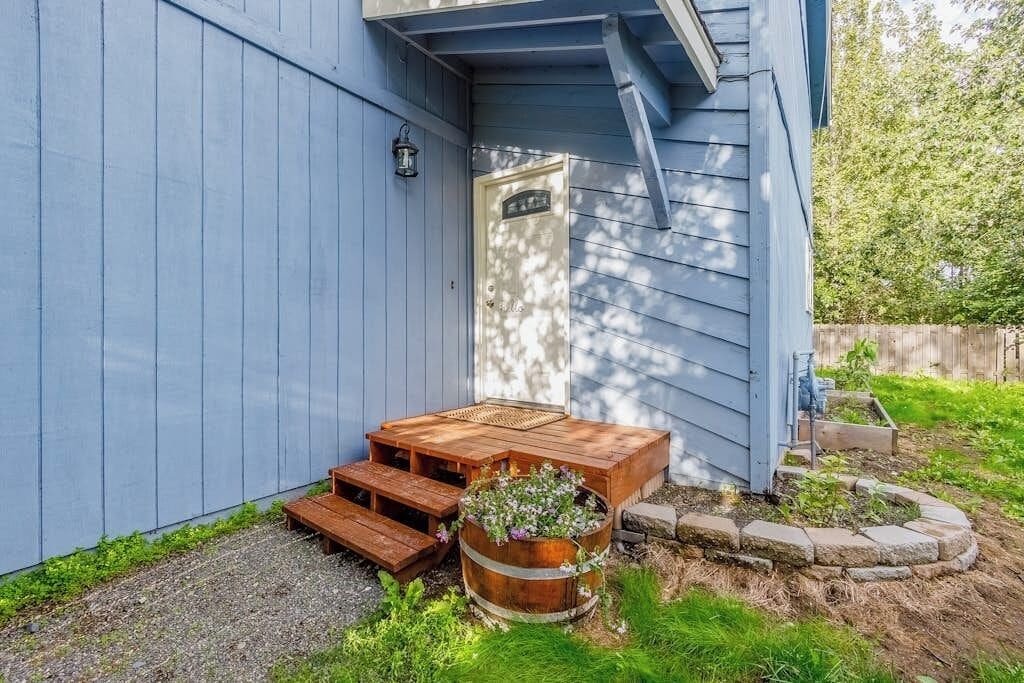A wooden deck with a bench and a planter with flowers.
