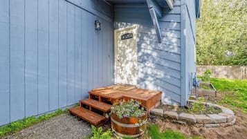 A wooden deck with a bench and a planter with flowers.