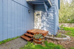 A wooden deck with a bench and a planter with flowers. - Quiet Anchorage Neighborhood Home w/ Walking Trail (Anchorage)