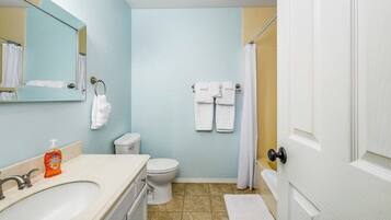 A bathroom with a sink, toilet, and a mirror.